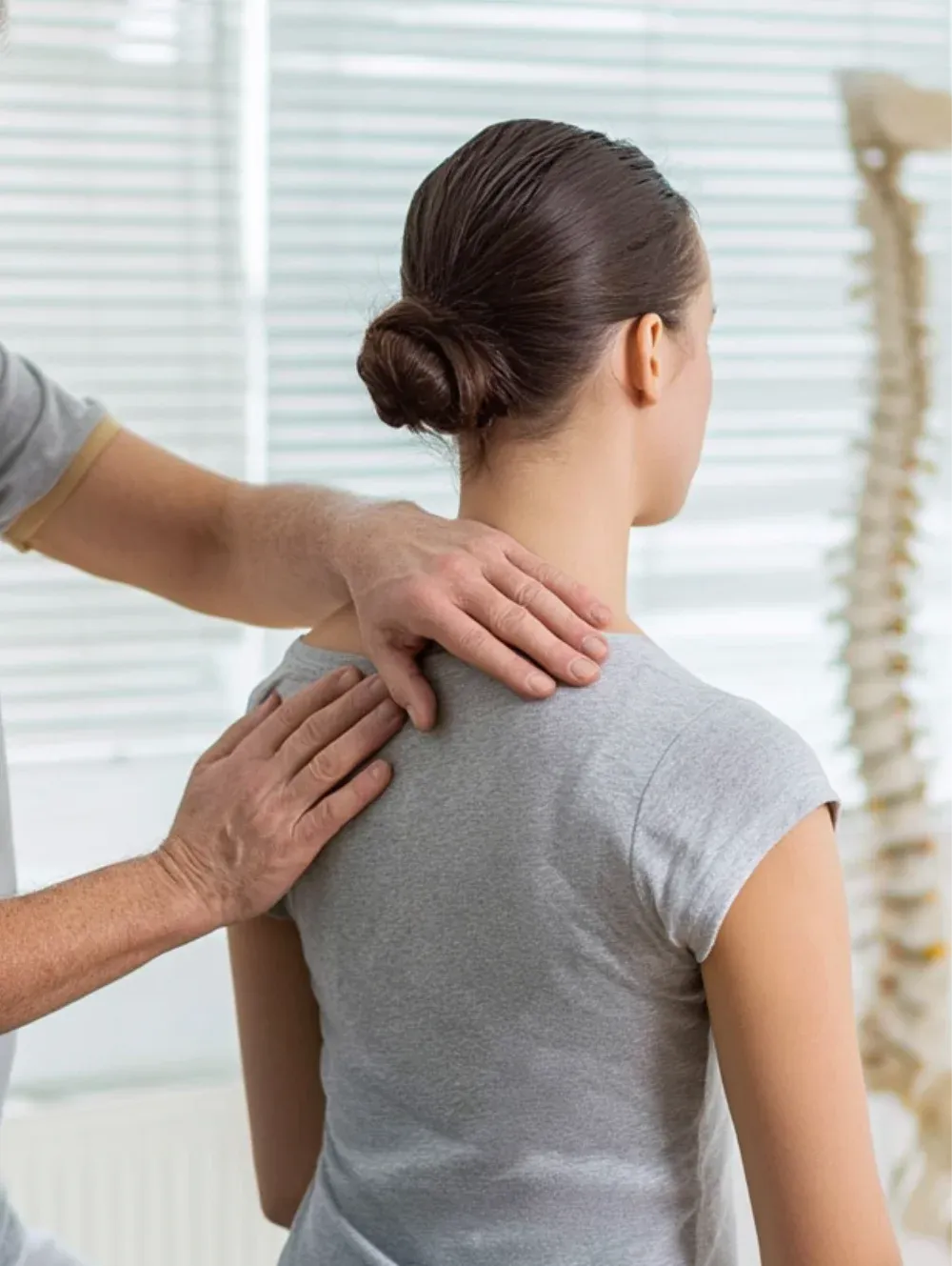 Hände an Schulter und oberem Rücken einer Patientin